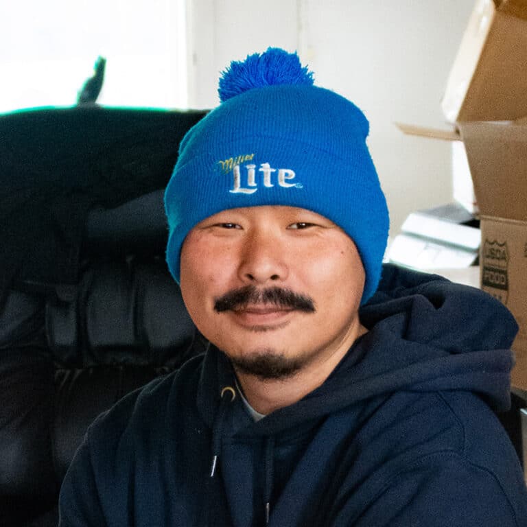 Man wearing a blue hat and hoodie smiling